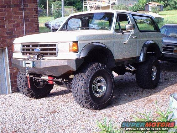 White 1991 Ford Bronco with aftermarket bumper and winch