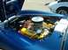1995 Ford Crown Victoria - The engine bay of a blue sports car is visible, with a white car parked nearby.