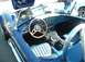 1995 Ford Crown Victoria - The interior of a blue convertible sports car features a wood-rimmed steering wheel and a dashboard filled with gauges.