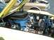 1995 Ford Crown Victoria - The engine compartment of a vintage yellow car is shown, with another classic vehicle in the background.