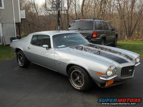 Silver 1970 Chevrolet Camaro with black stripes, front 3/4 view. License plate visible