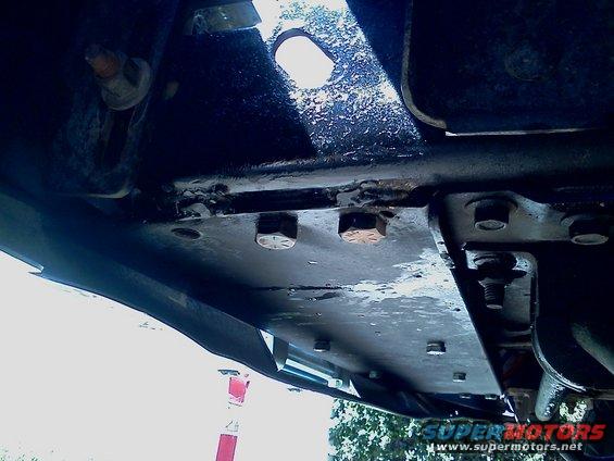 Close-up of vehicle frame with bolts and mounting plates visible