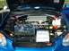 1995 Ford Crown Victoria - Engine bay of a blue Subaru WRX STI, an intercooler and a display with a model car and information sheet.