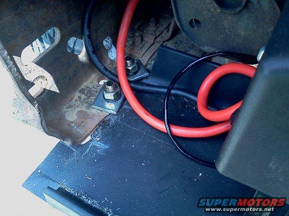 Close-up of winch mount wiring with red and black cables secured by bolts