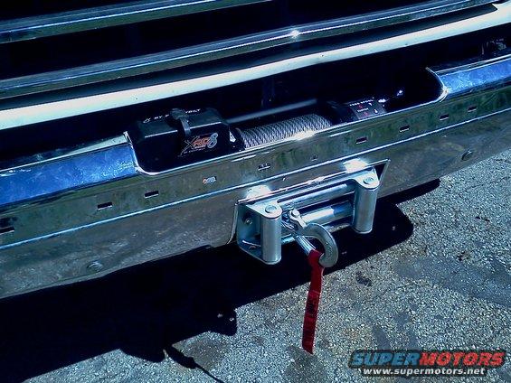 Chrome bumper with a winch and red strap attached to a hook