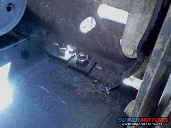 Winch mount bolts and brackets on a dark metal surface