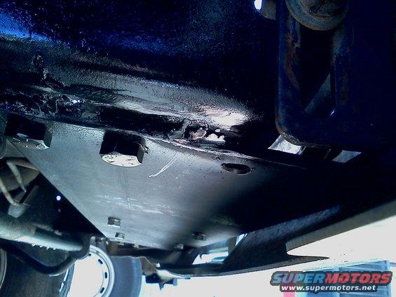 close-up of metal skid plate bolted to vehicle frame