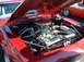 1995 Ford Crown Victoria - Engine bay of a red car with the hood open, showing a V8 engine and chrome accents.