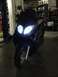 2008 Yamaha Zuma - A black scooter is shown from the front with its headlights on.