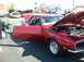 1995 Ford Crown Victoria - A red 1969 Chevrolet Camaro is displayed with its hood open, showing the engine.