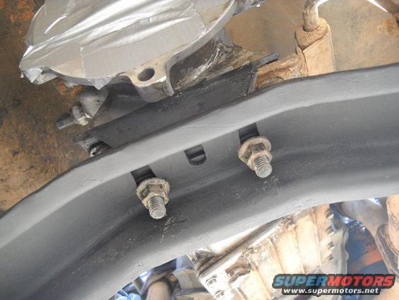 Close-up of rusted bolts on a vehicle's undercarriage frame