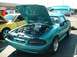 1995 Ford Crown Victoria - Teal Ford Mustang hatchback with hood and trunk open, parked next to a yellow Mustang.