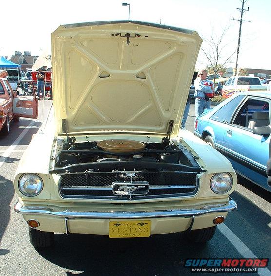 Yellow 1965 Mustang with hood open, showing engine. Blue car next to it
