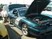 1995 Ford Crown Victoria - A 1995 Ford Mustang GT is displayed with its hood open, next to a white pickup truck.
