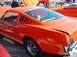 1995 Ford Crown Victoria - Side view of an orange 1965 Ford Mustang coupe at a car show.