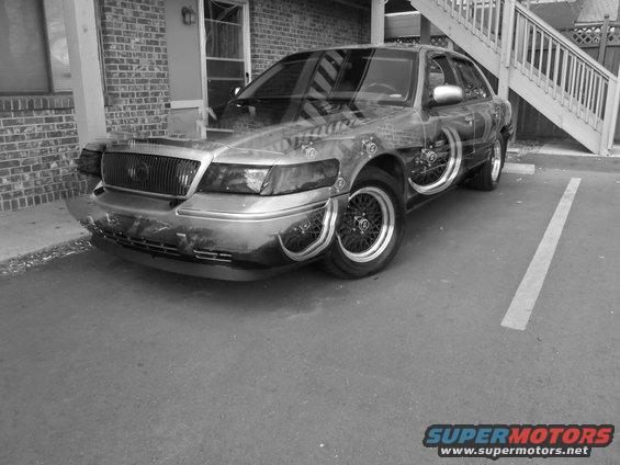 Sedan with custom paint and exposed wheel wells, parked in a lot