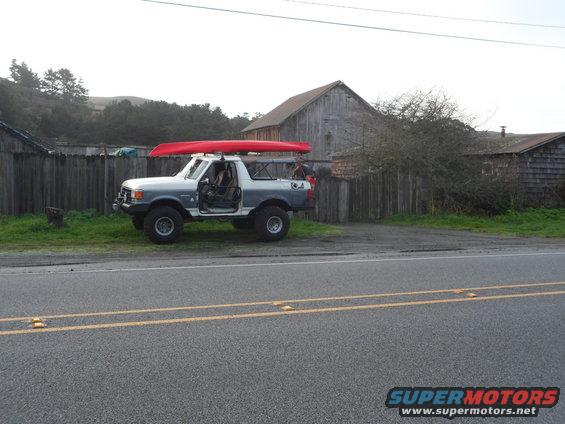 Two-tone pickup truck with canoe on roof, side view