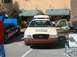 1995 Ford Crown Victoria - A tan and brown police car is parked next to a car painted with the American flag.