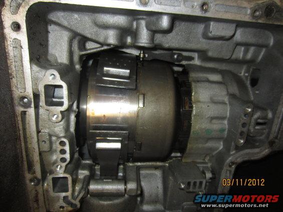 Transmission torque converter inside a gray metal housing, with visible date stamp 03/11/2012