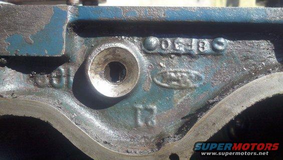 Close-up of a blue engine block casting with Ford logo and numbers stamped on it
