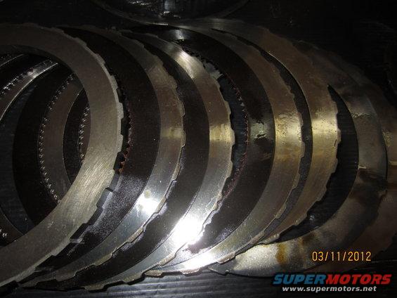 Stack of transmission clutch plates, some showing wear