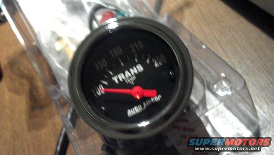 Auto Meter transmission temperature gauge with red needle pointing to 140 degrees