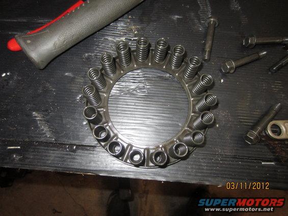 Clutch pressure plate with springs and bolts on a workbench