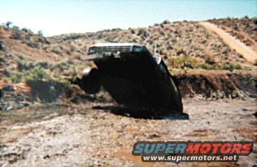 Overturned black SUV on a dirt road