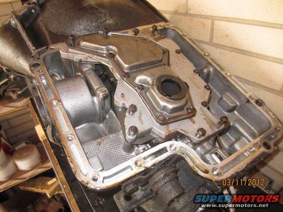 Transmission pan with filter assembly removed, showing internal components and gasket residue
