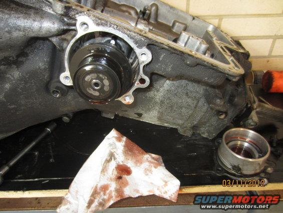 Transmission pump assembly with stained paper towel and metal ring on black surface