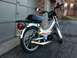1999 Tomos Targa - A silver Tomos moped with a gold exhaust pipe is parked in front of a garage door.