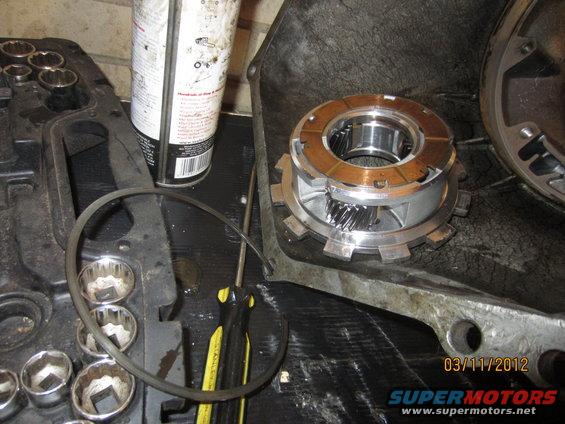 Transmission planetary gear set with clutch plates and a gasket ring on a workbench with tools