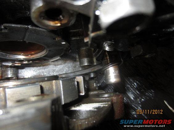 Close-up of internal transmission components with oil. Date stamp reads 03/11/2012