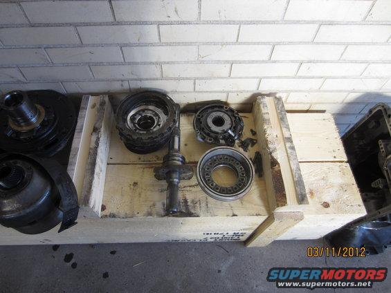 Transmission components, including clutches and shafts, laid out in a wooden crate