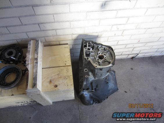 Transmission housing and some circular parts next to a wooden crate. Date stamp 03/11/2012