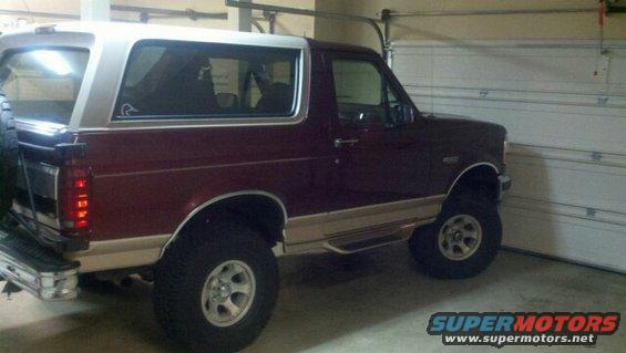 Maroon and tan SUV, rear quarter view. Spare tire mounted on rear door