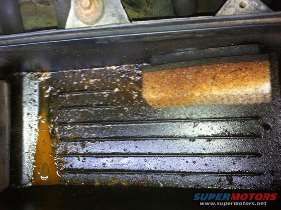 Engine oil filter housing with accumulated grime and oil residue