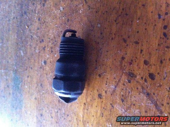 Used spark plug on a wooden surface