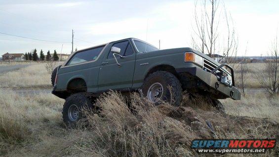 Green 1989 Ford Bronco on rough terrain