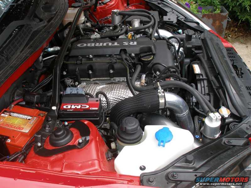 Engine bay showing turbocharger, battery, and fluid reservoirs