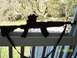 1989 Ford Bronco - A black SKS rifle with an optic and sling is displayed on a railing with a wooded background.