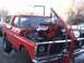 1978 Ford Bronco - A red 1978 Ford Bronco is shown from the front as its engine is being installed using an engine hoist.