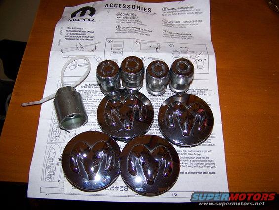 Mopar wheel locks and center caps with Ram logos, laid out on an instruction sheet