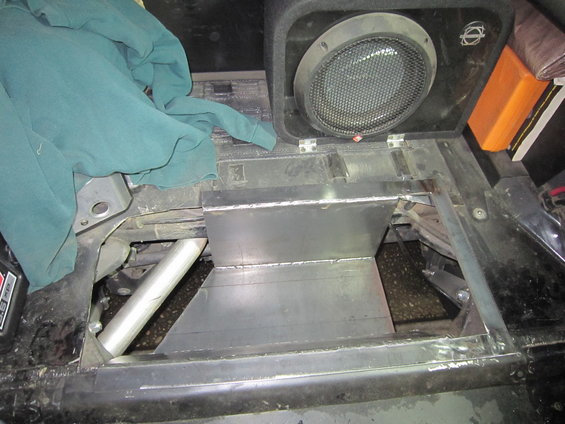 Interior view of a custom metal storage compartment and speaker installed in a vehicle
