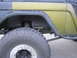 1974 Ford Bronco - A close-up side view of a 1974 Ford Bronco highlights its off-road modifications, including a large tire and suspension system.