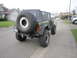 1974 Ford Bronco - Rear view of a modified 1974 Ford Bronco with a soft top and oversized spare tire.