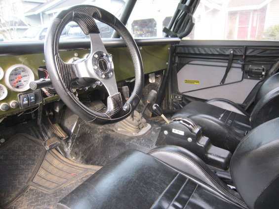 Interior view of a modified off-road vehicle with aftermarket steering wheel and gauges