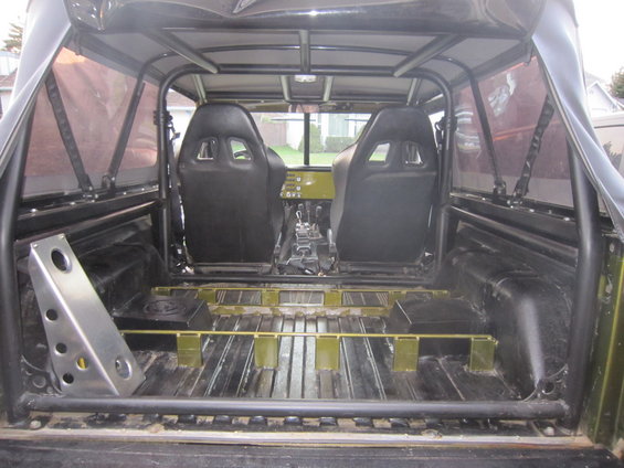SUV interior with roll cage, racing seats, and exposed metal floor