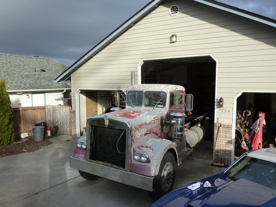 Old truck with peeling paint, parked in driveway
