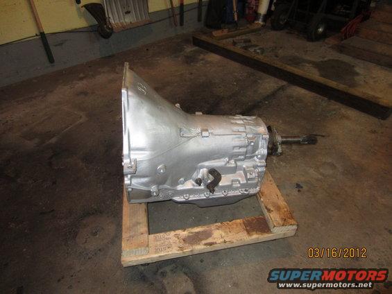 Silver automatic transmission on a wooden pallet in a garage